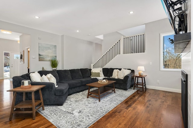 living room featuring stairway, baseboards, wood finished floors, and recessed lighting