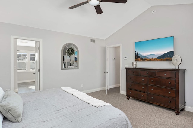 bedroom featuring lofted ceiling, light colored carpet, visible vents, ensuite bath, and baseboards