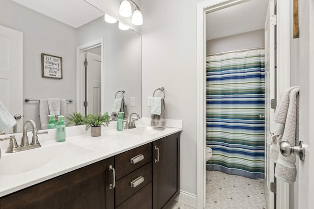 bathroom with double vanity, toilet, a sink, and a shower with shower curtain