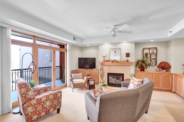 living area with recessed lighting, visible vents, a high end fireplace, and light carpet