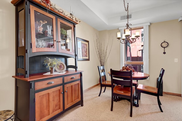 dining room with visible vents, baseboards, light colored carpet, and a notable chandelier