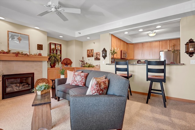 living room featuring recessed lighting, light colored carpet, a raised ceiling, and baseboards