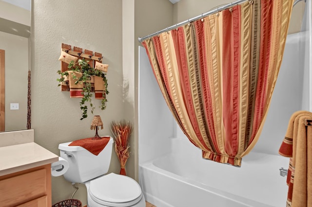 bathroom featuring vanity, toilet, and a textured wall