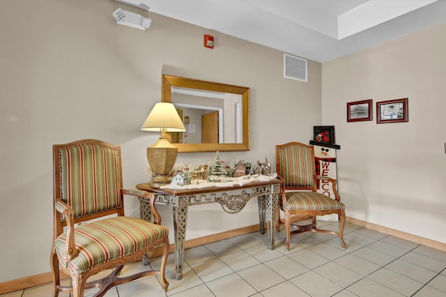 living area featuring light tile patterned floors, baseboards, and visible vents