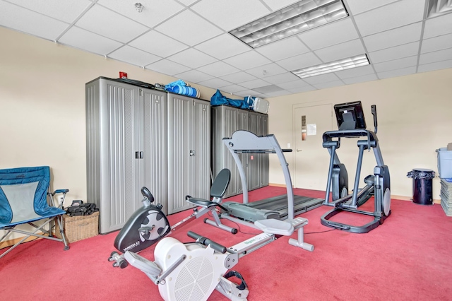 exercise room featuring a paneled ceiling and carpet floors