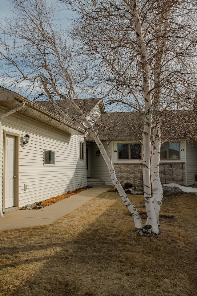 view of front of property featuring a front yard and brick siding