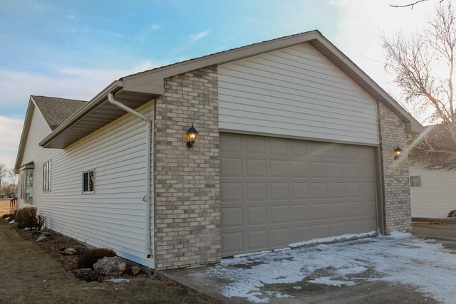 view of side of home with brick siding and an attached garage