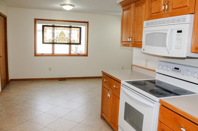 kitchen featuring baseboards, white appliances, brown cabinetry, and light countertops