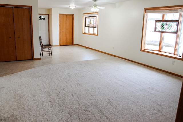 unfurnished room featuring tile patterned floors, baseboards, carpet, and a ceiling fan