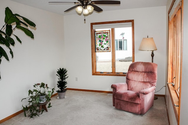 sitting room featuring carpet flooring, baseboards, and ceiling fan