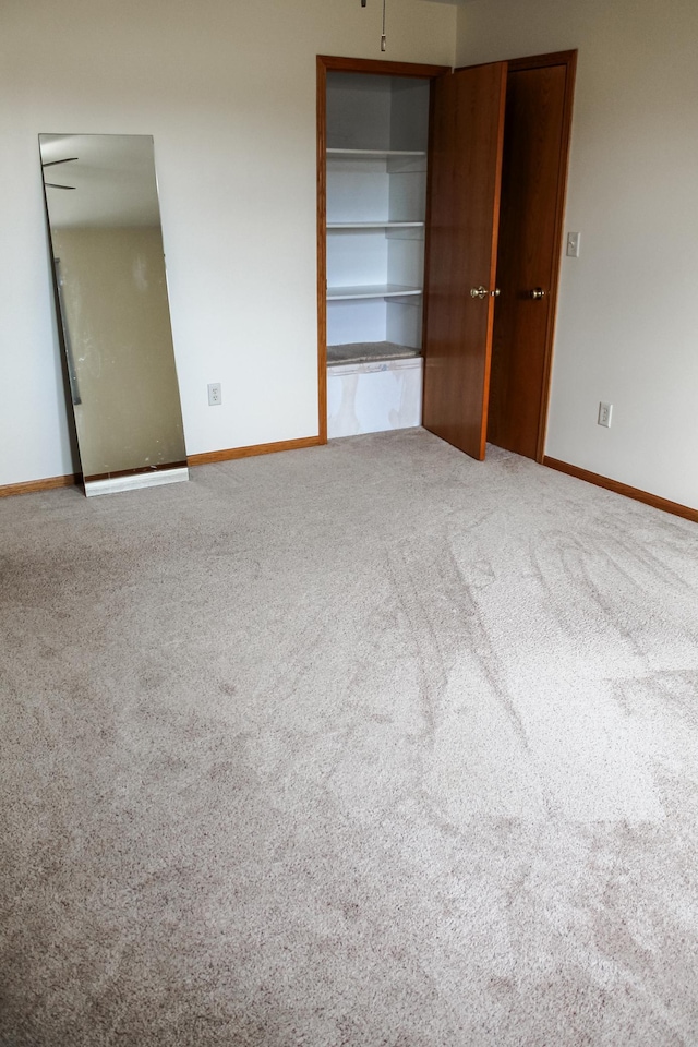 unfurnished bedroom with carpet flooring and baseboards