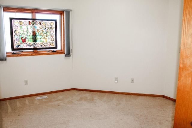 carpeted empty room with visible vents and baseboards