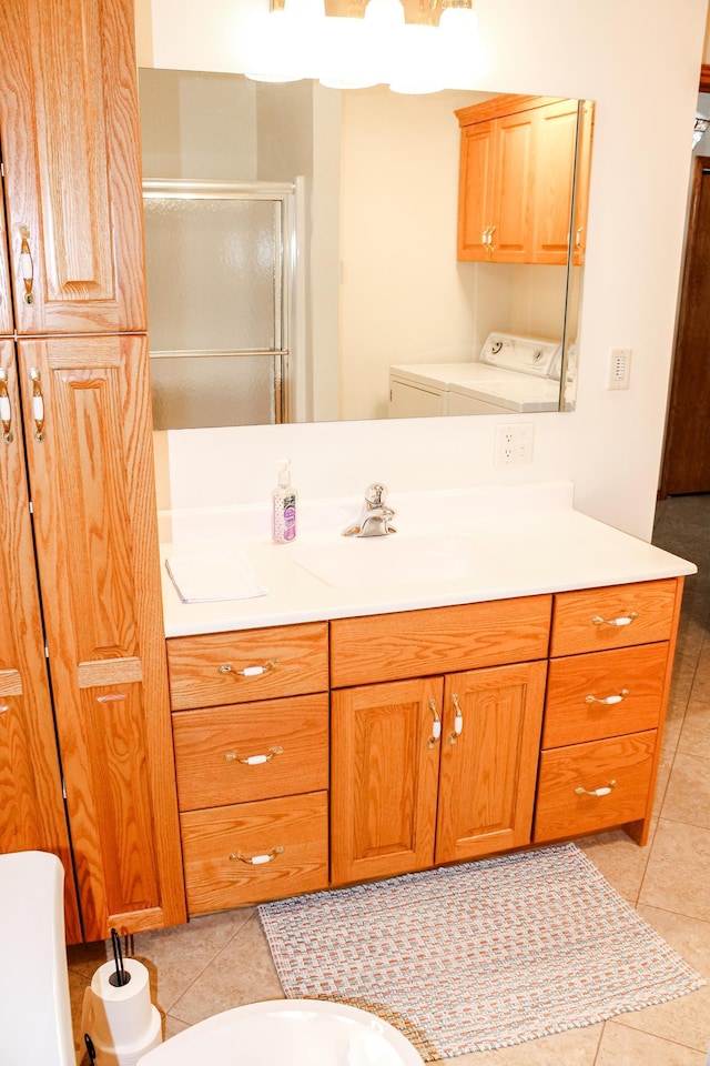 bathroom featuring washer and dryer, tile patterned floors, vanity, and a stall shower