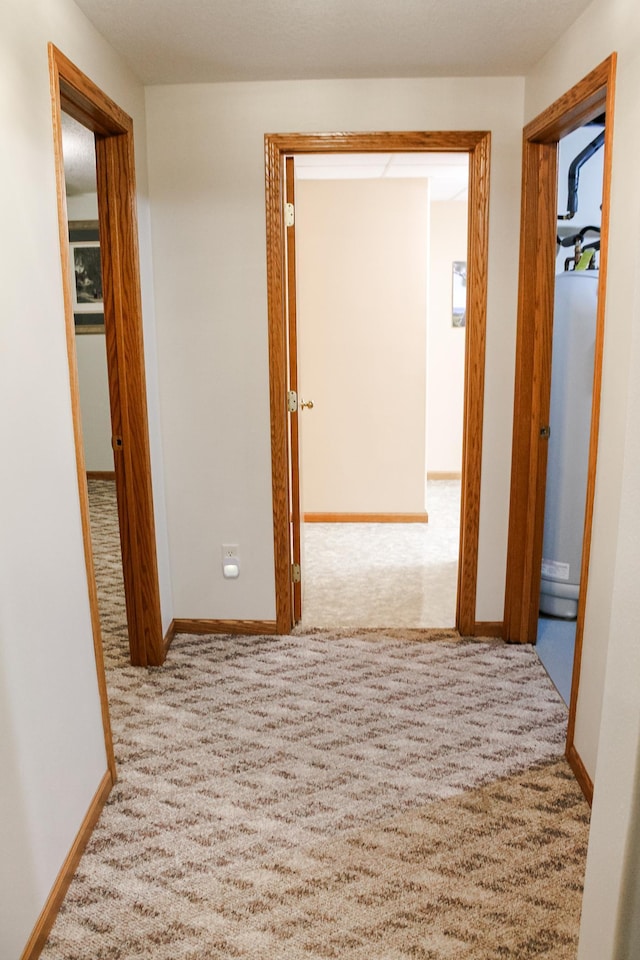 corridor with baseboards, carpet floors, and a baseboard radiator