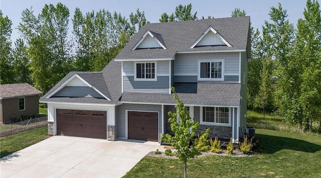 craftsman-style home featuring roof with shingles, concrete driveway, an attached garage, stone siding, and a front lawn