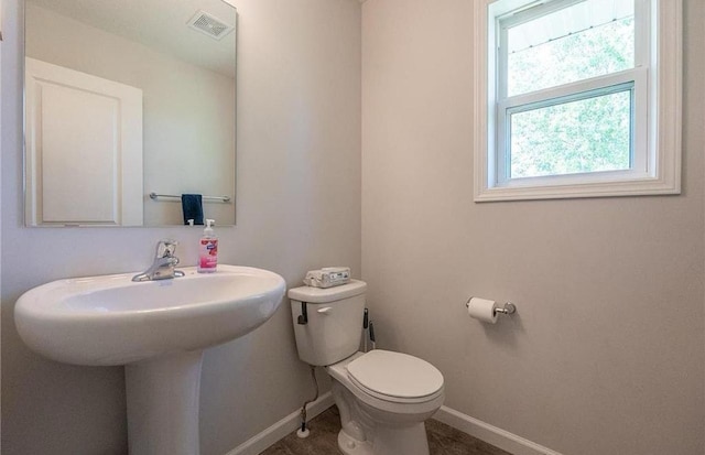 bathroom featuring baseboards, visible vents, and toilet