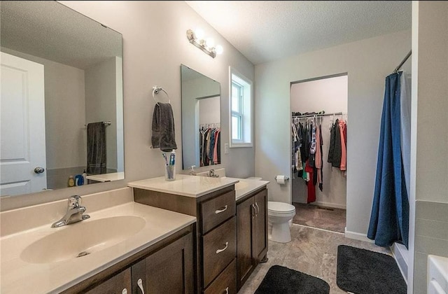 bathroom with baseboards, a shower with shower curtain, toilet, a textured ceiling, and vanity