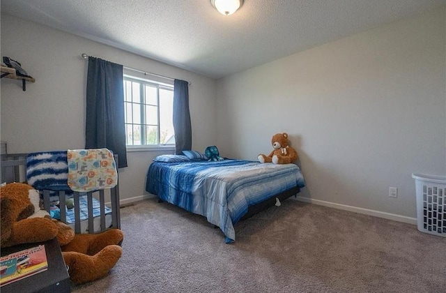 bedroom with a textured ceiling, carpet floors, and baseboards