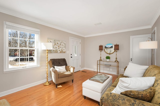 living room with light wood-type flooring, baseboards, and ornamental molding