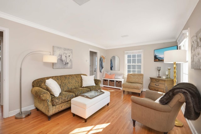 living area with baseboards, ornamental molding, and light wood-style floors