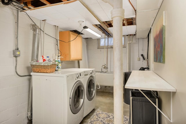 laundry area featuring washing machine and dryer, cabinet space, and a sink