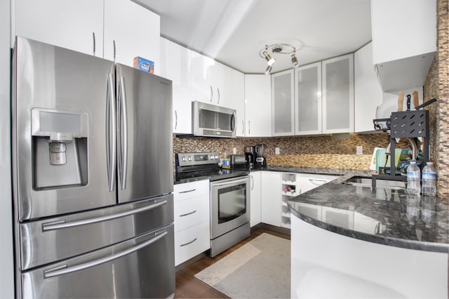 kitchen with a sink, backsplash, appliances with stainless steel finishes, and white cabinets