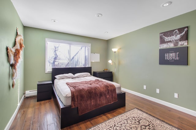 bedroom with recessed lighting, a baseboard heating unit, baseboards, and wood finished floors