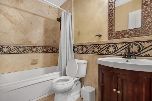 bathroom with a wainscoted wall, toilet, vanity, shower / bath combination with curtain, and tile walls