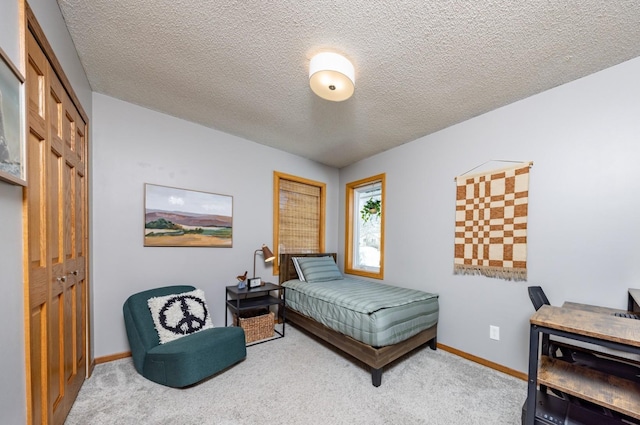 carpeted bedroom featuring a closet, a textured ceiling, and baseboards