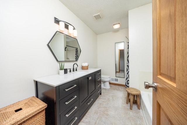 bathroom with toilet, visible vents, a textured ceiling, and vanity