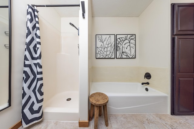 bathroom with a garden tub, a textured ceiling, and a shower stall