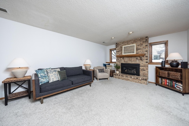 living area with carpet, a fireplace, visible vents, and a textured ceiling