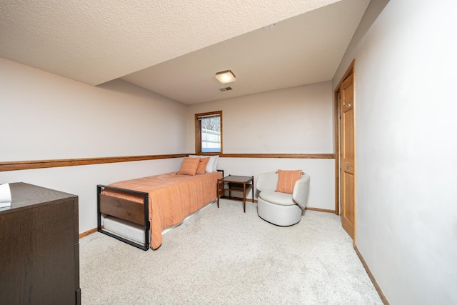 bedroom with a textured ceiling, carpet floors, and baseboards