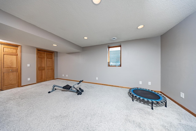 workout area with recessed lighting, carpet, a textured ceiling, and baseboards