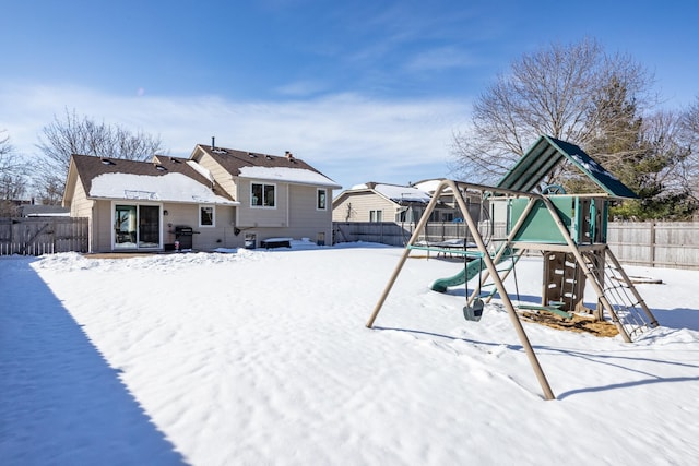 exterior space with a trampoline, a playground, and fence