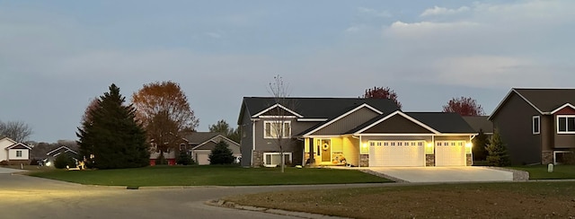 view of front facade with a residential view, driveway, an attached garage, and a front yard