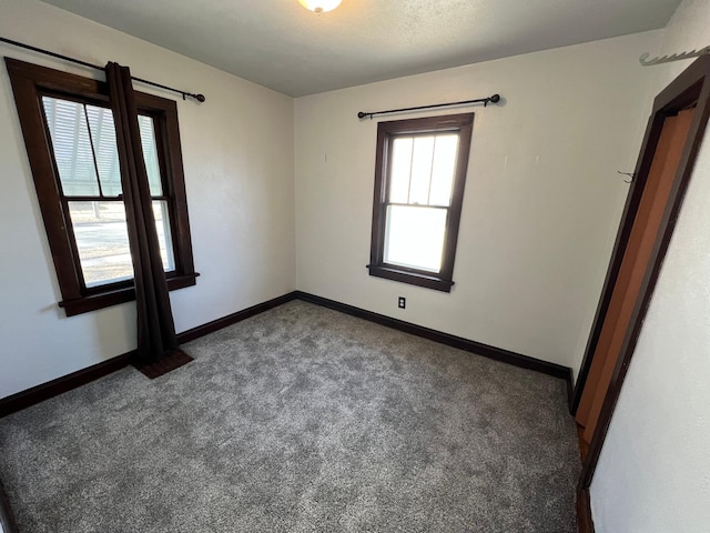 carpeted spare room with baseboards