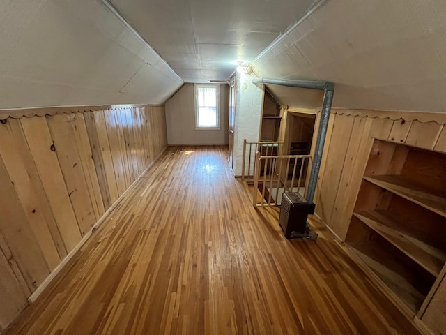 bonus room with wood finished floors, wood walls, and vaulted ceiling