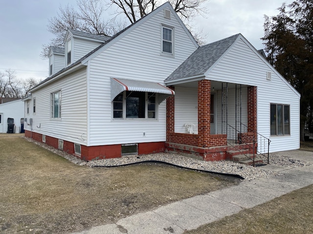 view of front of house featuring a shingled roof and a front lawn