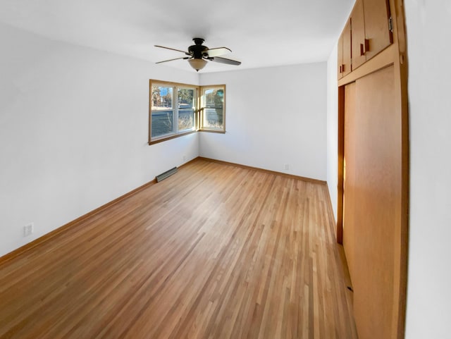 unfurnished bedroom with a closet, light wood-style flooring, a ceiling fan, and baseboards