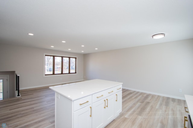 kitchen with recessed lighting, a kitchen island, light wood-style flooring, and white cabinets