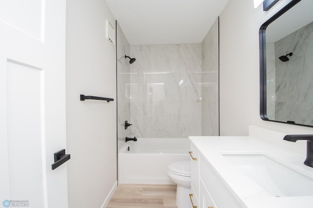 bathroom featuring toilet, shower / washtub combination, wood finished floors, and vanity