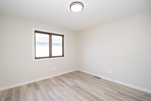 empty room with visible vents, baseboards, and light wood finished floors