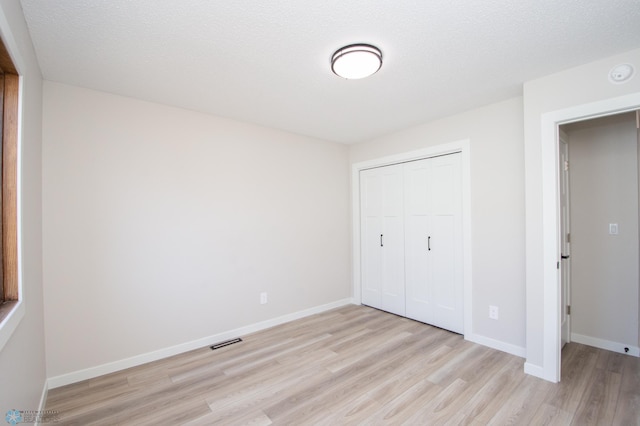 unfurnished bedroom featuring visible vents, baseboards, and light wood-style floors