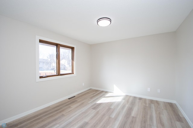 empty room with visible vents, baseboards, and light wood-style floors