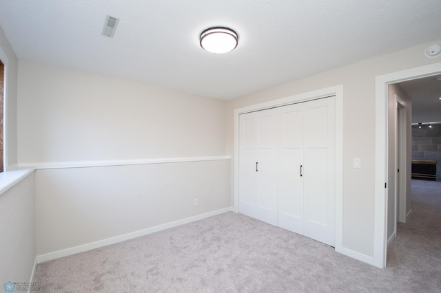 unfurnished bedroom with visible vents, baseboards, carpet, and a closet