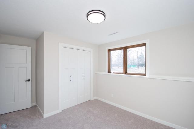 unfurnished bedroom with a closet, visible vents, baseboards, and carpet