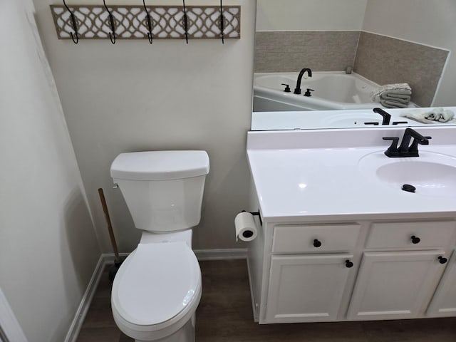 bathroom featuring toilet, vanity, baseboards, and wood finished floors