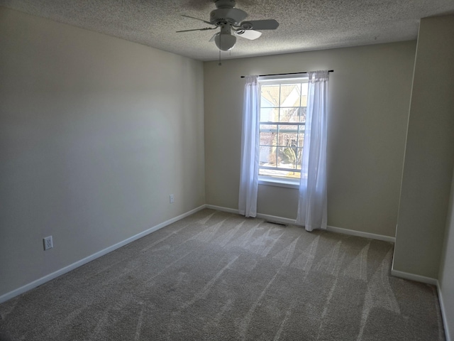 spare room featuring baseboards, carpet, a ceiling fan, and a textured ceiling