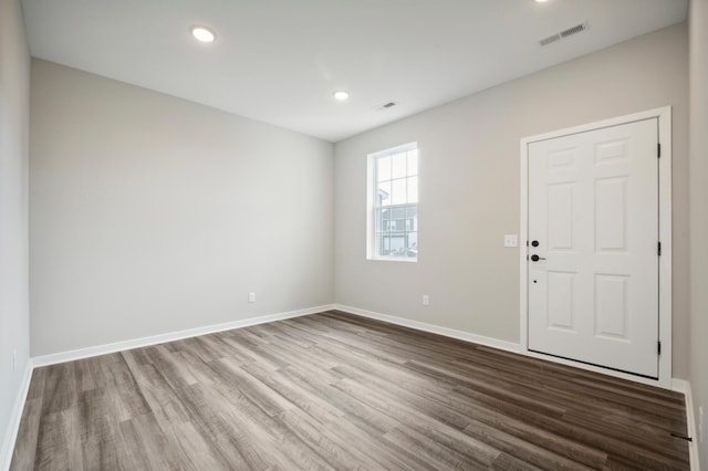 unfurnished room with recessed lighting, visible vents, baseboards, and wood finished floors